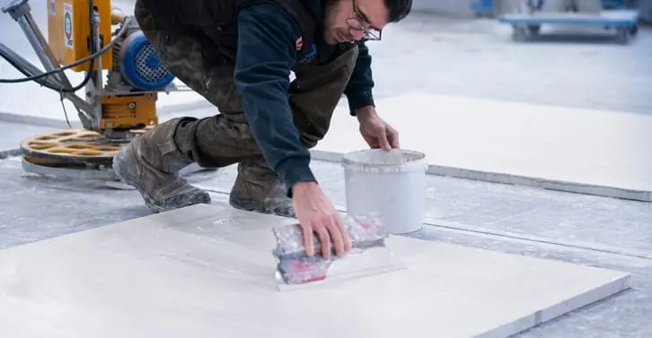 Finition à la truelle d'une plaque de terrazzo en atelier
