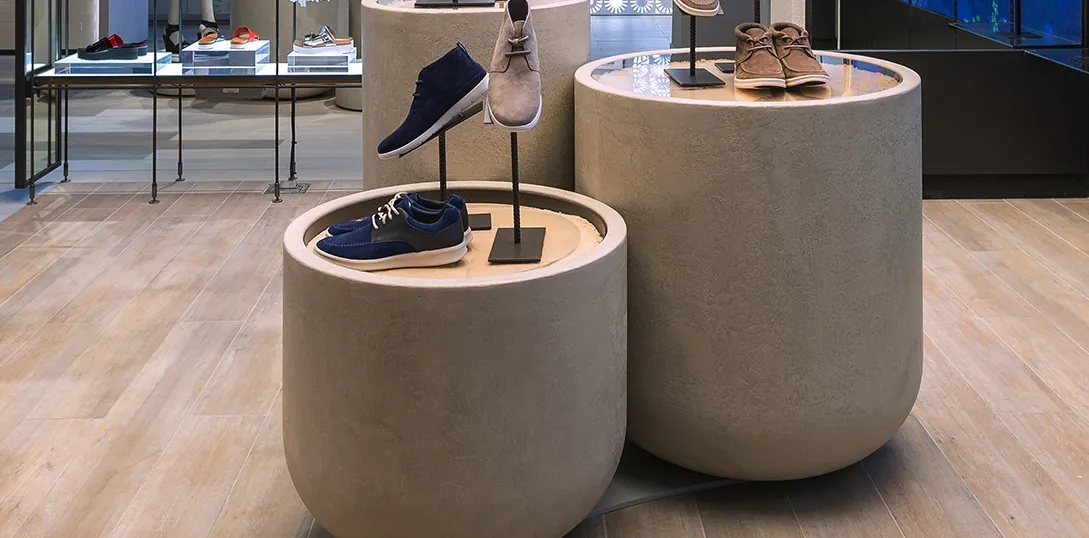 Présentoirs ronds en béton ciré, finition grain, dans une boutique de chaussures