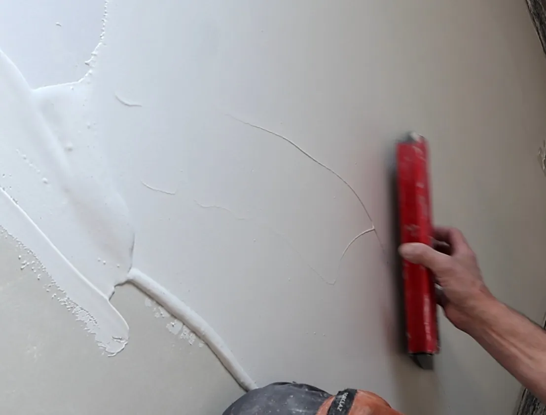 Application du béton ciré à la lisseuse sur un mur