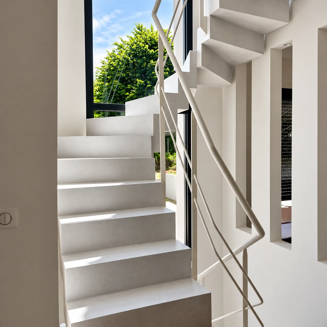 Escalier en béton ciré blanc éclairé par une fenêtre