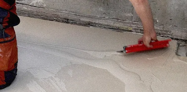 Un applicateur étale le béton ciré LucemChoc au sol à la lisseuse