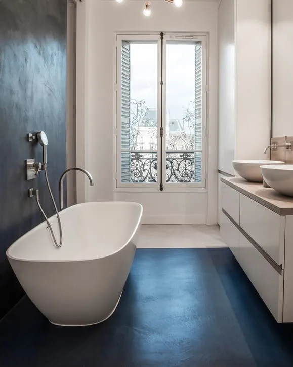 Salle de bain avec baignoire îlot sur un sol en béton ciré bleu nuit LucemChoc Récif 193 – appartement à Paris